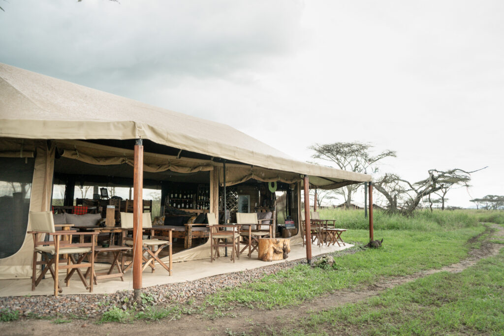 Vista esterna del Mawe Tented Camp Hotel con tavoli da pranzo allestiti in un campo erboso