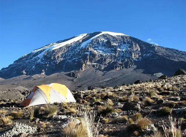 A tent pitched with the majestic Mount Kilimanjaro in the background, ideal for climbers and adventurers.