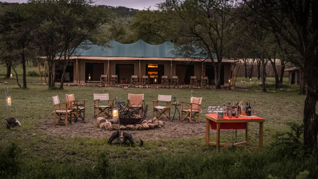 Outdoor fireplace with a chairs around at the Singing Grass Camp