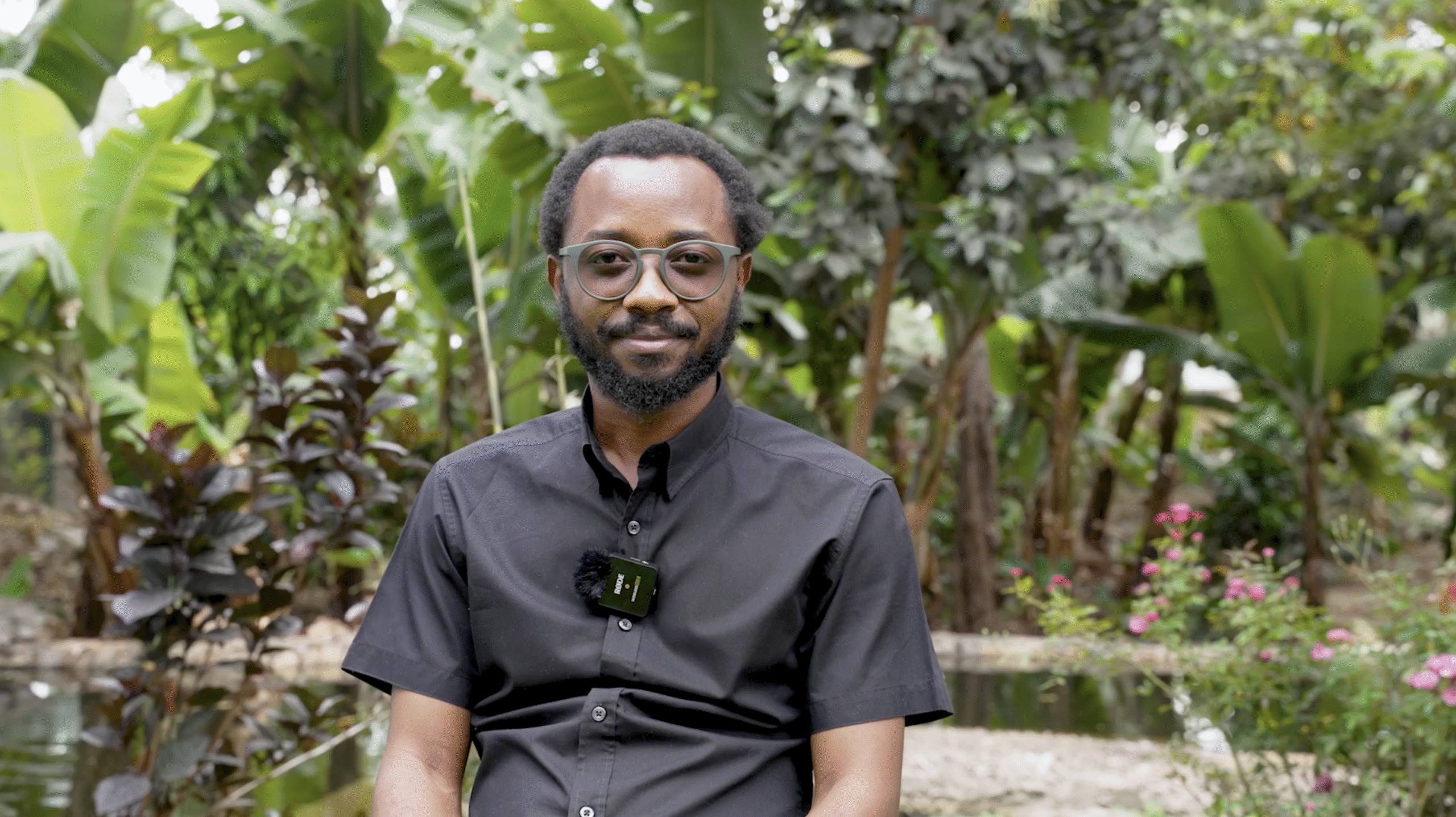 A Kilidove Tours team member speaking to camera in a lush green garden