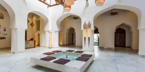 Elegant interior with marble floors, arched doorways, lanterns, and central seating at Park Hyatt Zanzibar