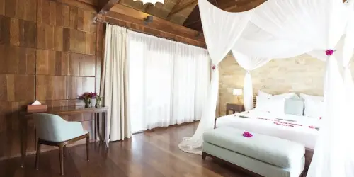 Wooden roof and wall, beautiful white covered double bed villa at Tulia Zanzibar Beach Resort