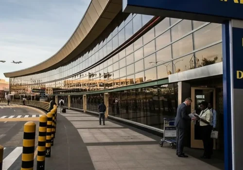 Yellow and black signs line the entrance of the kenya Jomo Kenyatta Nairobi Airport, providing directional information.