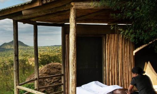An outdoor massage setup on a wooden deck with a scenic natural backdrop