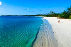 Tourist Walking on Beach of Mafia Island Two people walking on a Mafia Island Beach with clear blue waters and white sand